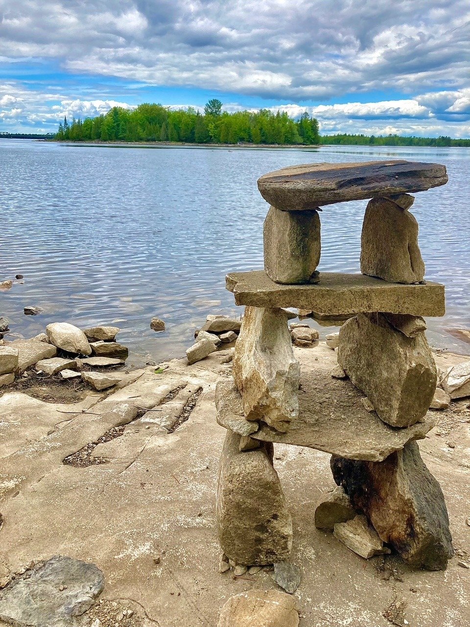 A stone inukshuk on the shoreline of the Ottawa River