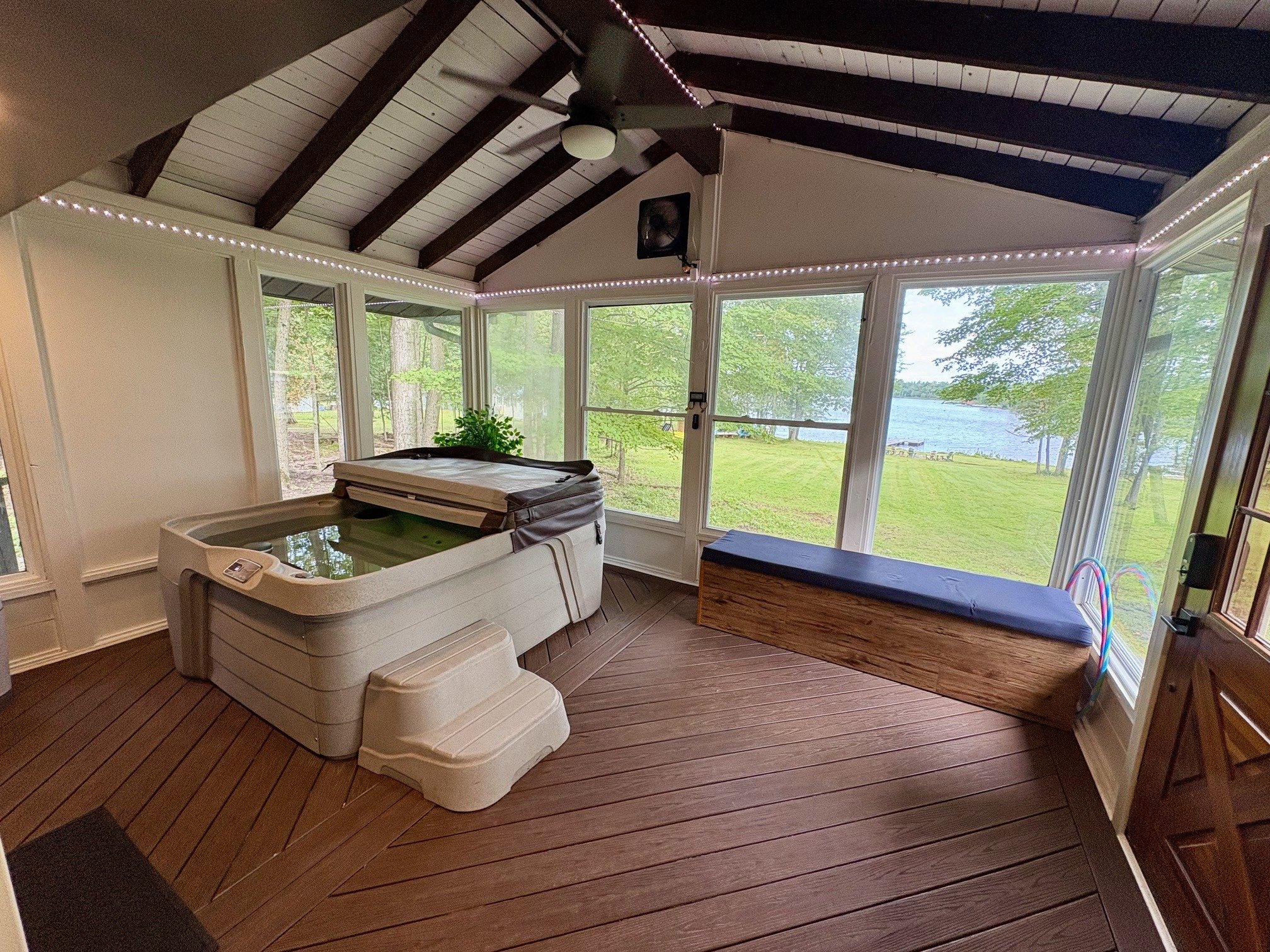 Hot tub in the sunroom with a lake view through the screened windows
