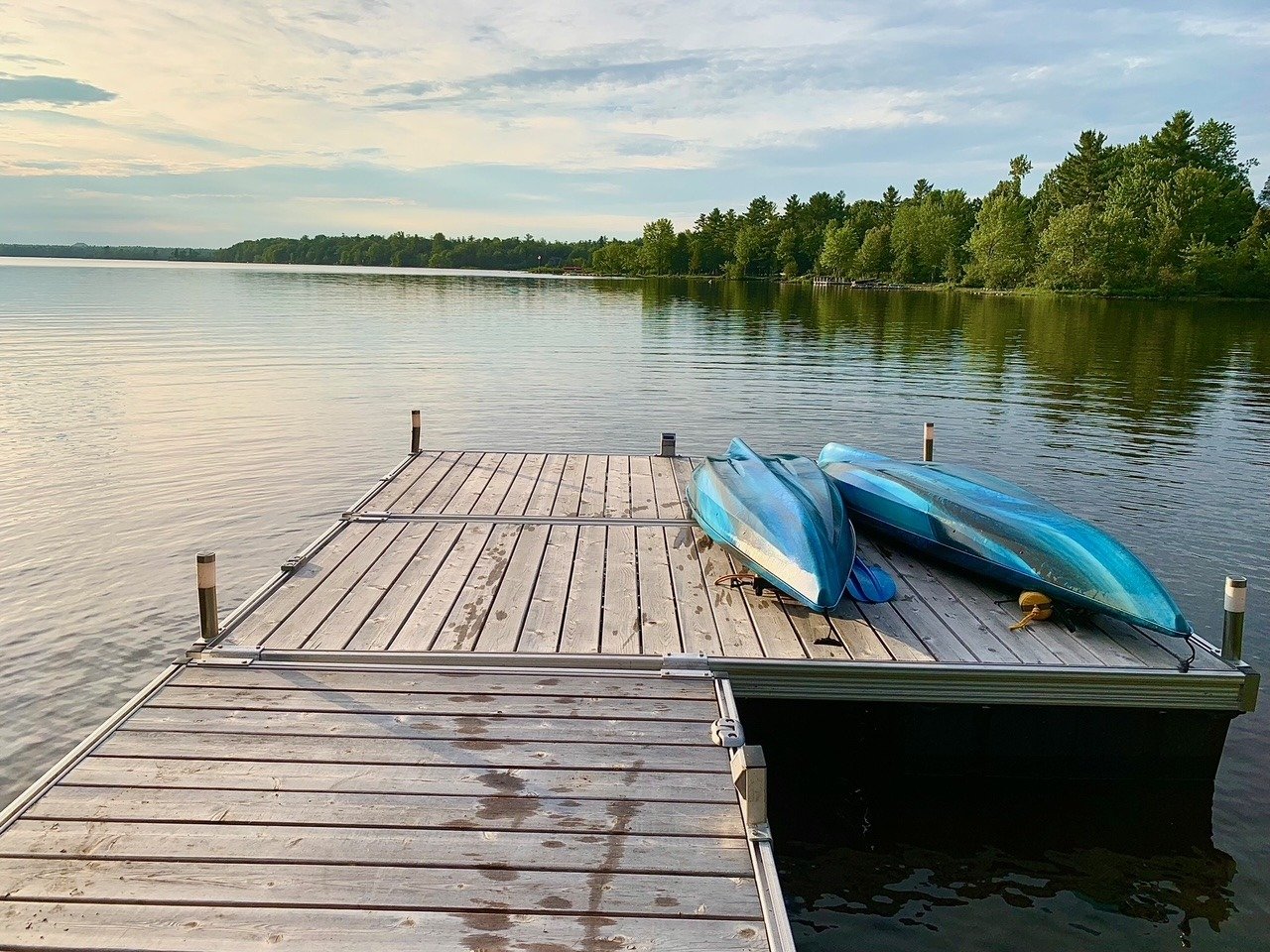 Kayaks resting at the end of the dock at golden hour
